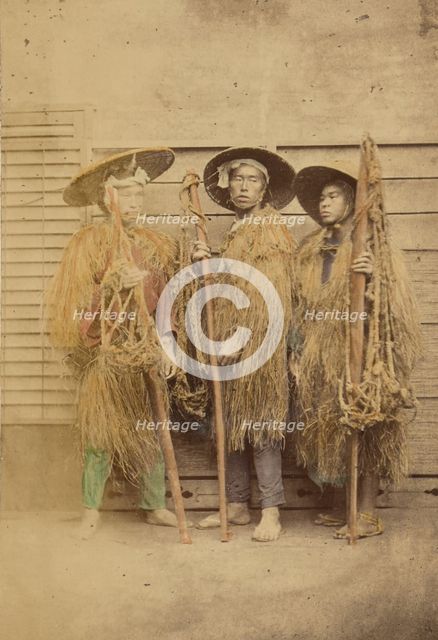 Three Japanese men in grass robes and wide-brimmed hats, 1868-1880. Creator: Felice Beato.