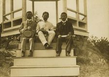 Three Japanese men, possibly journalists, seated on the steps of a gazebo, 1905. Creator: Unknown