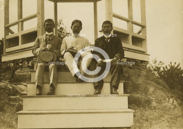 Three Japanese men, possibly journalists, seated on the steps of a gazebo, 1905. Creator: Unknown.