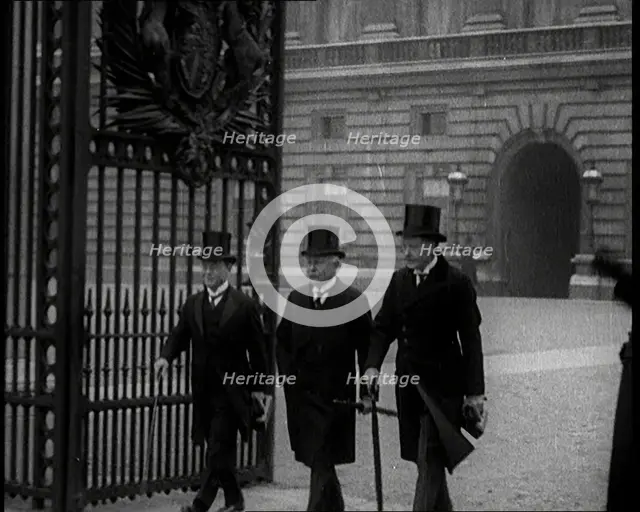 Three Male British Members of Parliament Walking Away from Buckingham Palace, Passing..., 1924. Creator: British Pathe Ltd.