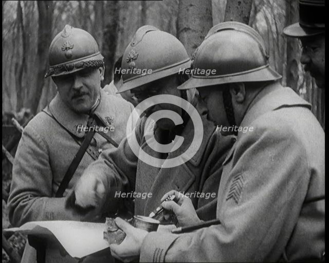 Three Male French Soldiers Standing in a Wood Looking at a Map, 1924. Creator: British Pathe Ltd.