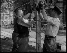 Three Men Setting up a Barbed Wire Fence, 1940. Creator: British Pathe Ltd