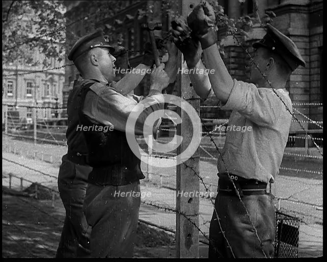 Three Men Setting up a Barbed Wire Fence, 1940. Creator: British Pathe Ltd.