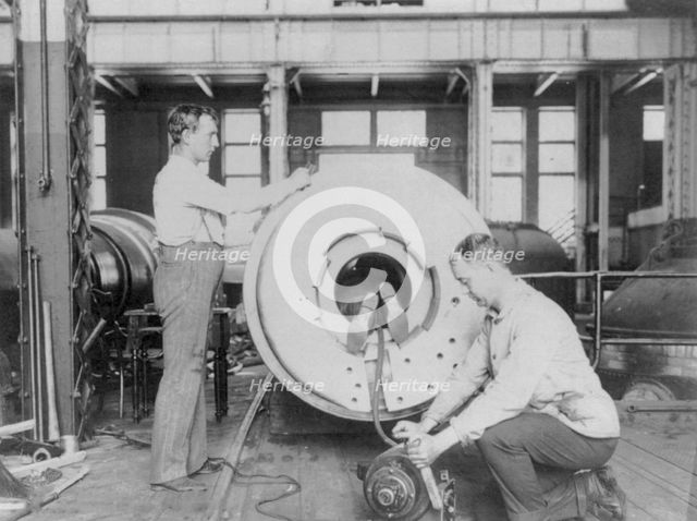 Three men working on large gun in Naval Gun Factory, Washington, D.C., one of the men lying..., 1903 Creator: Frances Benjamin Johnston.