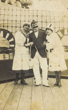 Three sailors, two in drag wearing pierrette costumes, pose on deck, c1910s. Creator: Unknown