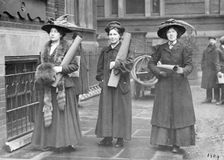 Three suffragettes prepare to chain themselves to the railings, 1909
