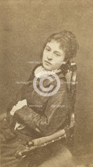 Three-quarter length portrait of woman, seated in chair, facing left, between 1880 and 1886. Creator: Unknown.