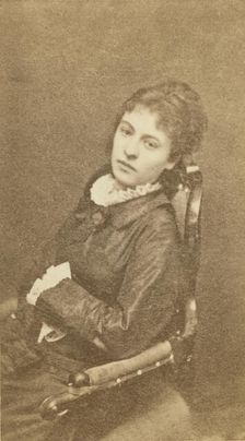 Three-quarter length portrait of woman, seated in chair, facing left, between 1880 and 1886. Creator: Unknown