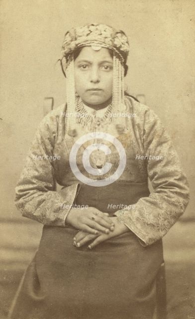 Three-quarters length portrait of a woman, seated, facing front, between 1870 and 1886. Creator: Unknown.