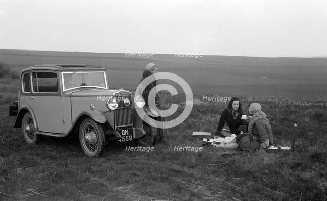 Three women having a picnic during a road test of a Triumph Scorpion, 1931. Artist: Bill Brunell.