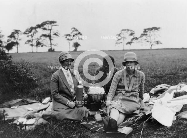 Three women having a picnic in a field, (1920s?). Artist: Unknown