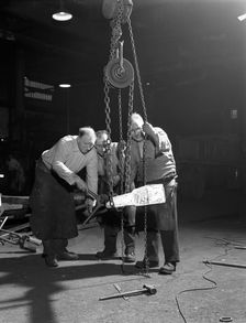 Three workers from Edgar Allen's handle a red hot billet, Sheffield, South Yorkshire, 1963. Creator: Michael Walters