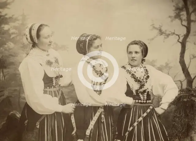 Three young women dressed in costumes from Leksand, Dalarna, 1886-1920. Creator: Helene Edlund.