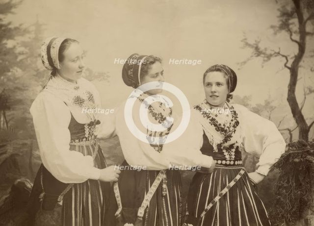 Three young women dressed in costumes from Leksand, Dalarna, 1886-1920. Creator: Helene Edlund.