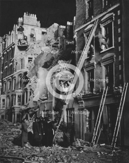 'Through the long night the rescue men at work, searching, helping to safety', 1941 (1942). Artist: Unknown.