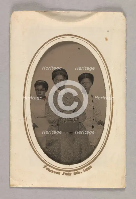 Tintype in a paper case of three unidentified young women seated, 1870s. Creator: Unknown.