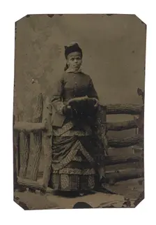 Tintype of woman in jacket and dress with hat and muff, 1880s. Creator: Unknown