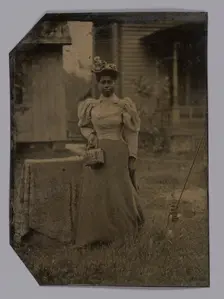 Tintype of a woman wearing a dress with hat and bag, 1890s. Creator: Unknown