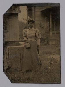 Tintype of a woman wearing a dress with hat and bag, 1890s. Creator: Unknown