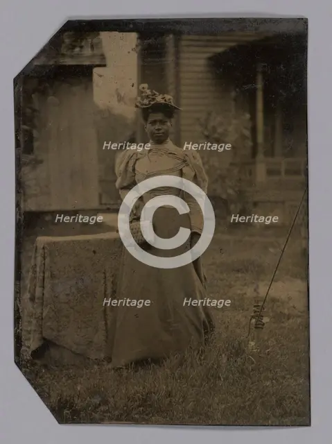 Tintype of a woman wearing a dress with hat and bag, 1890s. Creator: Unknown.