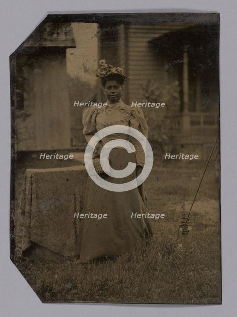 Tintype of a woman wearing a dress with hat and bag, 1890s. Creator: Unknown.