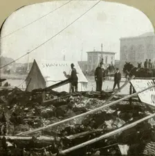 True grit - Barber painting sign on tent stretched on sidewalk of former place 1906. Creator: Unknown