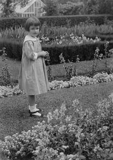Truesdale, Virginia, Miss, standing in a garden, 1915 July 21. Creator: Arnold Genthe