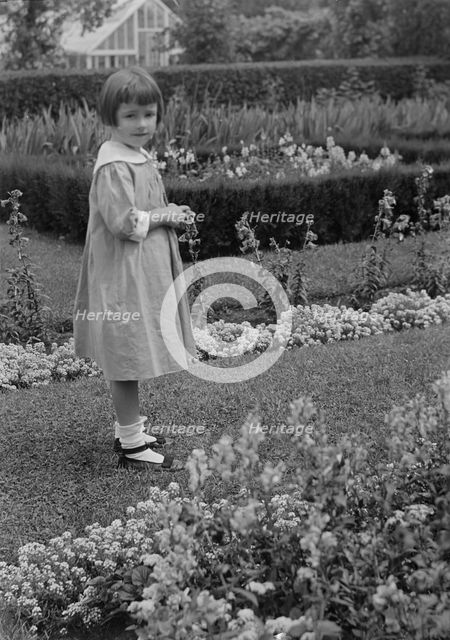 Truesdale, Virginia, Miss, standing in a garden, 1915 July 21. Creator: Arnold Genthe.