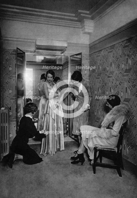 Trying on a dress at a great dressmakers, Paris, 1931.Artist: Ernest Flammarion