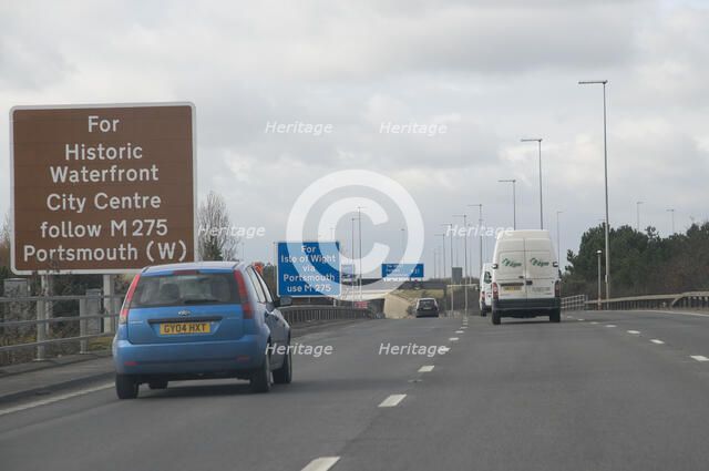 Traffic on M27 Motorway with brown tourist information sign