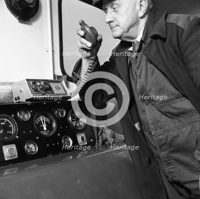 Train driver on an intercom, South Yorkshire, 1964. Creator: Michael Walters.