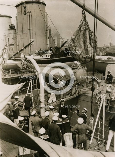 Transfering cases from H.M.S. Suffolk to H.M.S. Hood at Portsmouth, July 1935. Creator: Topical Press Agency.