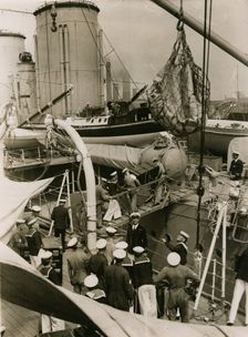 Transfering cases from H.M.S. Suffolk to H.M.S. Hood at Portsmouth, July 1935. Creator: Topical Press Agency