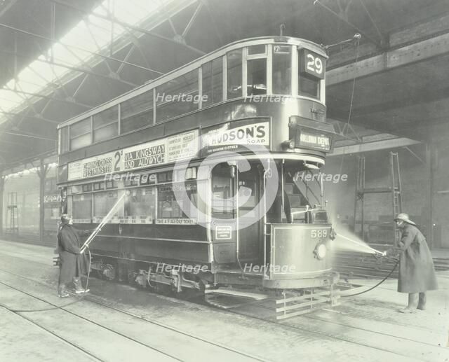 Transport workers washing a tram at the Holloway Car Shed, London, 1932.  Artist: Unknown.