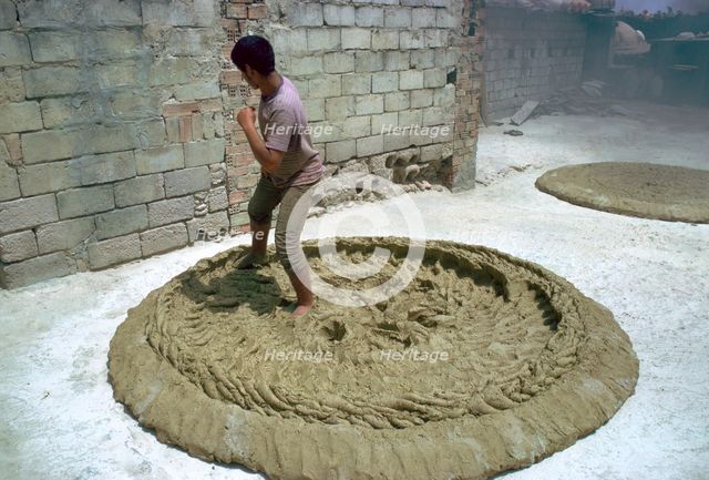 Treading clay for pottery in Tunisia. Artist: CM Dixon Artist: Unknown