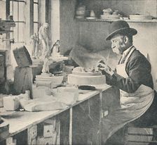 Trimming up parts of raw clay c1917
