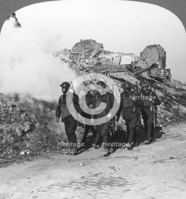 Troops passing the ruins of Monchy on the way up the line, France, World War I, c1914-c1918. Artist: Realistic Travels Publishers