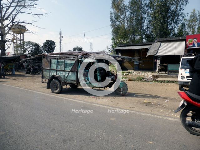 Tutuk carrying load of steel rods on roof, India 2017. Creator: Unknown.