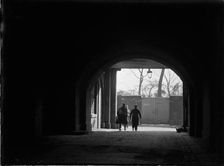 Tunnel or covered passage looking towards three figures, Greater London Authority, 1930s. Creator: Charles William Prickett