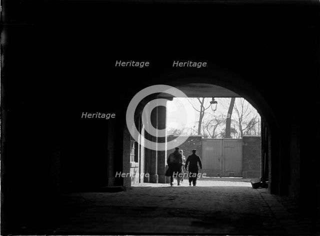 Tunnel or covered passage looking towards three figures, Greater London Authority, 1930s. Creator: Charles William  Prickett.