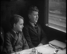Two Male Children in a Train Carriage Sitting in Front of a Table Laid for a Meal, 1931. Creator: British Pathe Ltd