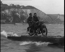 Two Male Civilians Riding a Motorcycle on a Float Across the English Channel, 1929. Creator: British Pathe Ltd