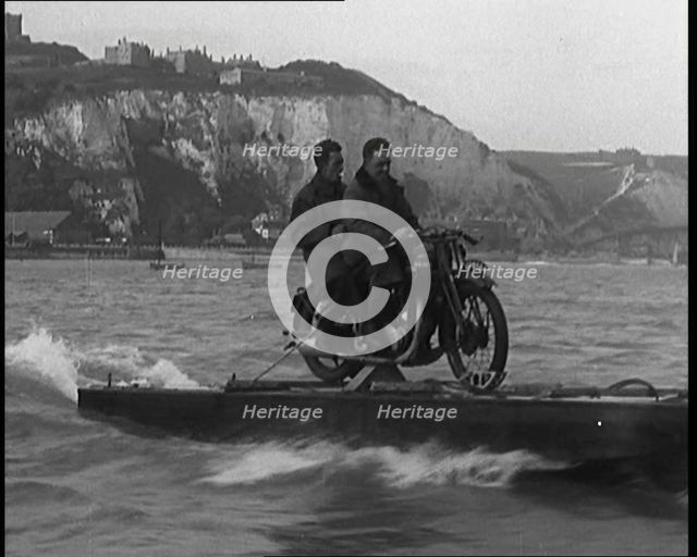 Two Male Civilians Riding a Motorcycle on a Float Across the English Channel, 1929. Creator: British Pathe Ltd.