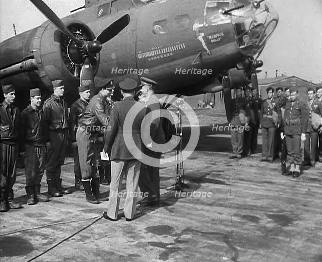 Two Male Officers Talking to a Group of Pilots in front of a Bomber Aircraft, 1943-1944. Creator: British Pathe Ltd.