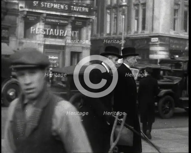 Two Male Politicians Walking Along a Busy Bridge Street Towards the Palace of Westminster, 1937. Creator: British Pathe Ltd.