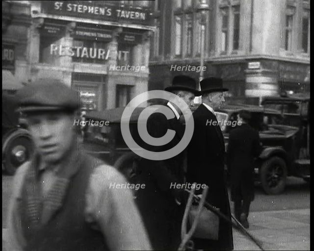 Two Male Politicians Walking Along a Busy Bridge Street Towards the Palace of Westminster, 1937. Creator: British Pathe Ltd.