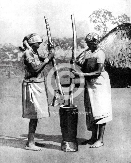 Two Mashona tribeswomen pounding maize and millet, Zimbabwe, Africa, 1936.Artist: Wide World Photos