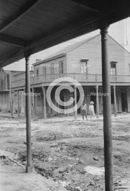 Two men crossing an unpaved street, New Orleans or Charleston, South Carolina, between 1920 and 1926 Creator: Arnold Genthe.