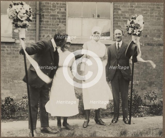 Two men holding tutti poles, with two women during the Hocktide Festival in Hungerford, 1925-35.  Creator: George R Long.