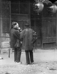 Two men, one holding a child, standing in the street, Chinatown, San Francisco, c1896-1906. Creator: Arnold Genthe